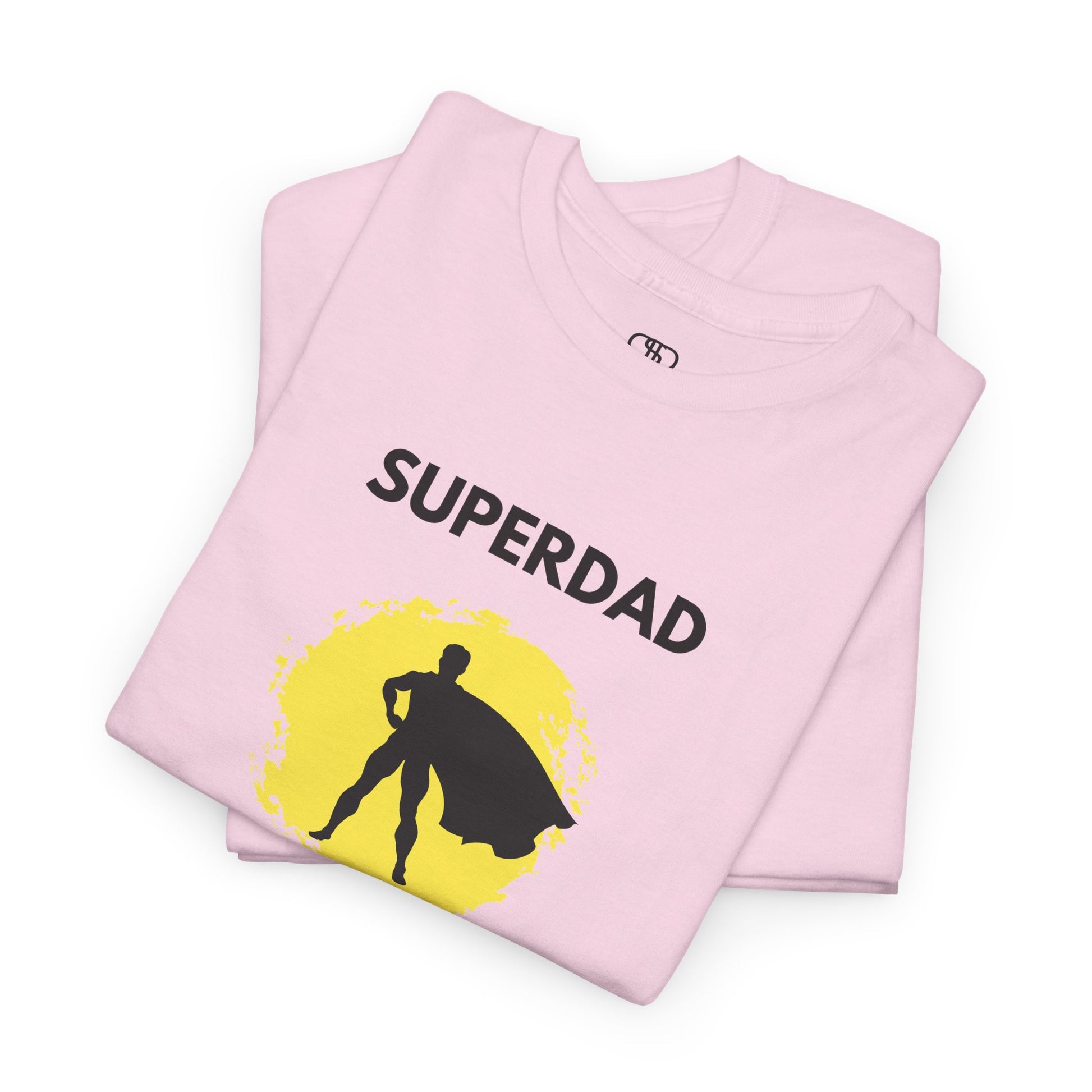  A folded light pink T-shirt with a "Superdad" text and a silhouette of a person with a cape on a yellow circle background.