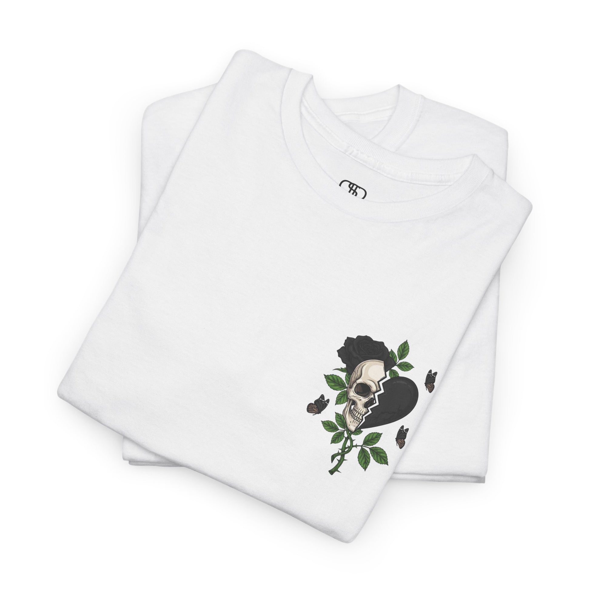 A folded white t-shirt with a front design of a half skull, half broken heart, and a rose. The back reads "Gym Heals" in black.