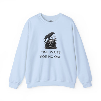 A sweatshirt featuring a detailed illustration of a crow perched on a human skull that is intertwined with overgrown vines and moss. Along with the words Time Waits For No One. 