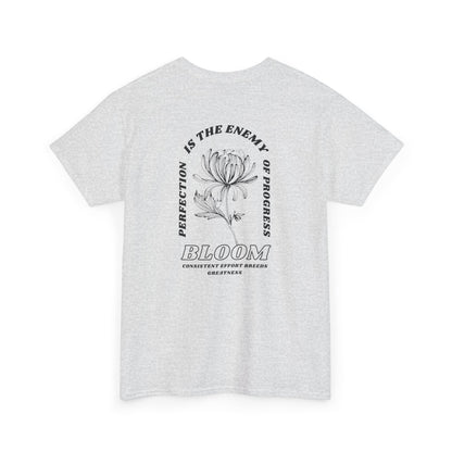 An [Ash Gray] t-shirt with a central flower design and the words “Perfection is the enemy of progress” and “Bloom” underneath it the phrase "Consistent effort breeds greatness," featured on the back of the t-shirt.