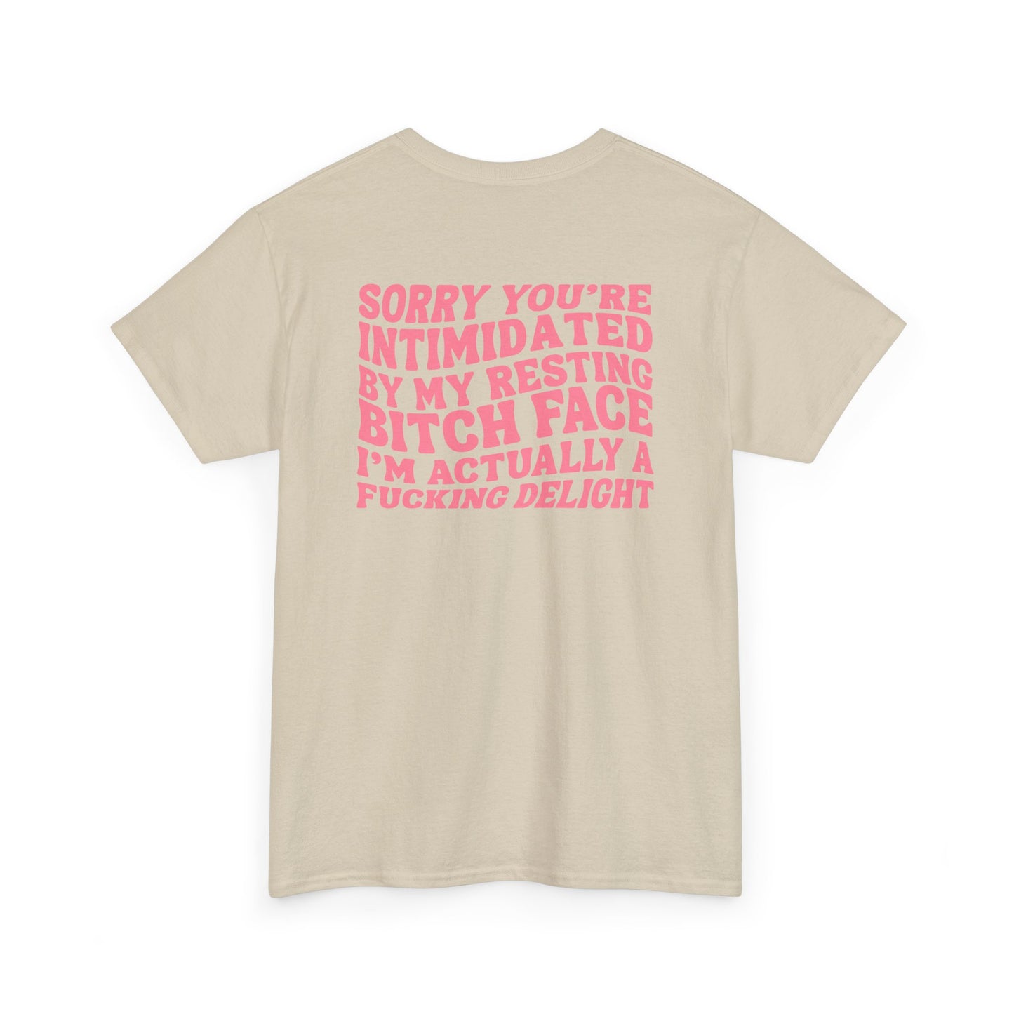 A sand t-shirt with a skeletal hand in a bubble on the front and the phrase “Sorry you’re intimidated by my resting Bitch ace I’m actually a fucking delight” on the back.